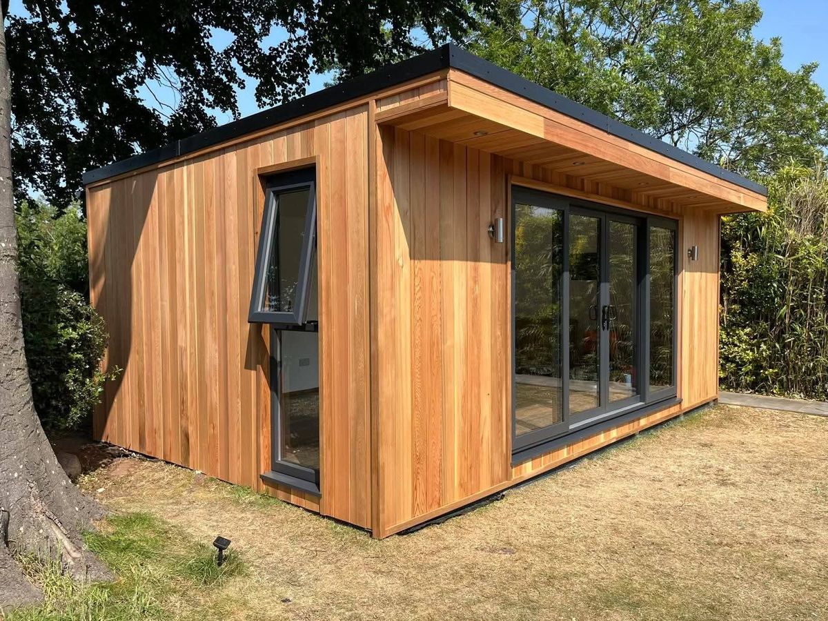 Cedar-clad Modulux garden room with dark aluminium sliding doors