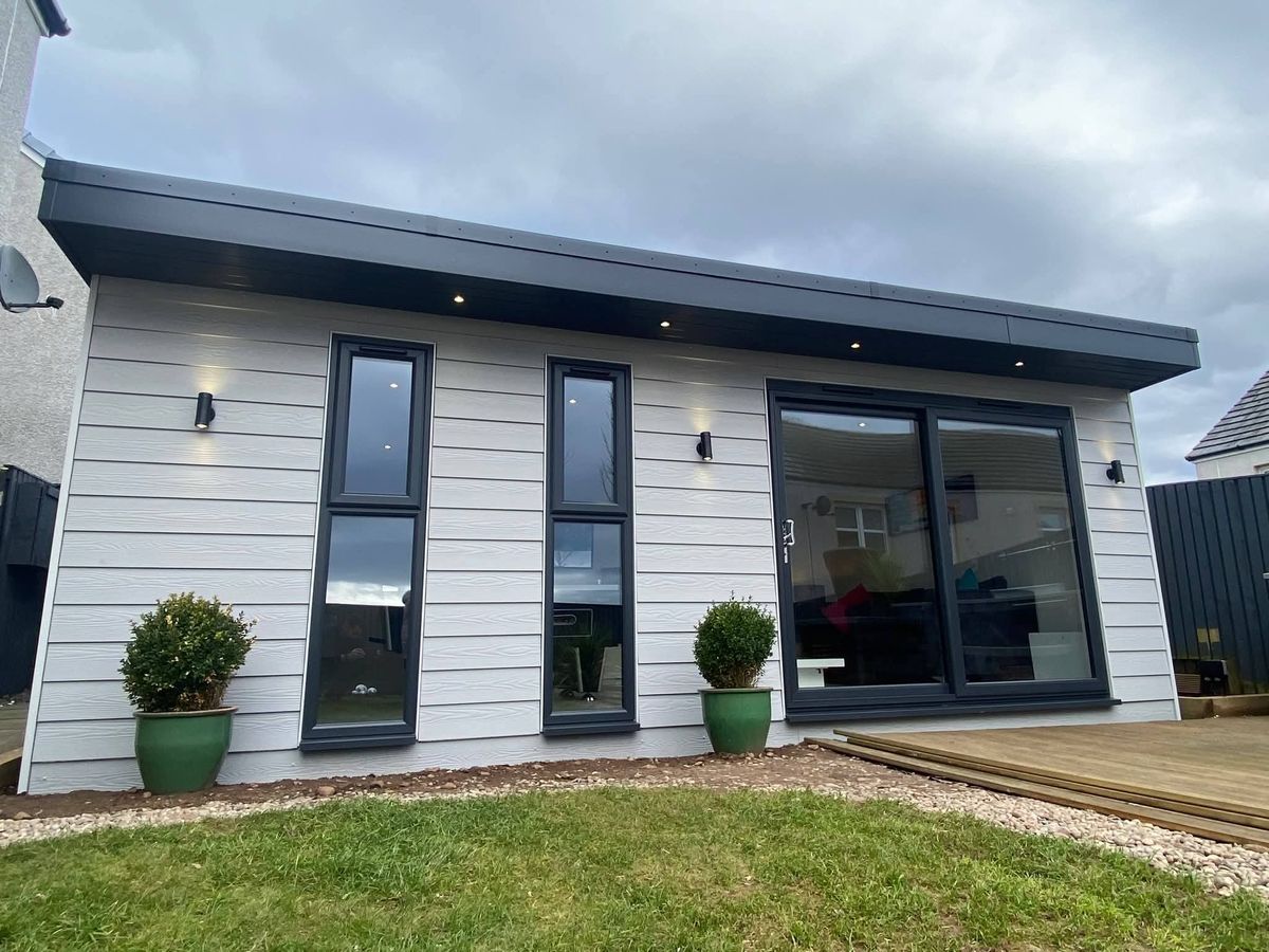 Rendered Modulux building with wide glazing and mature planting around it
